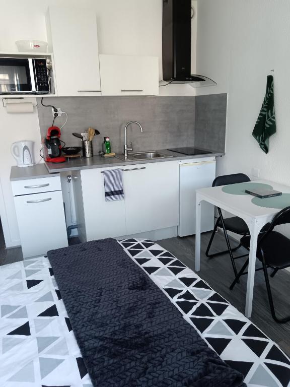 - une cuisine avec une table, un évier et une table dans l'établissement Studio Le Fournadet, à Dax