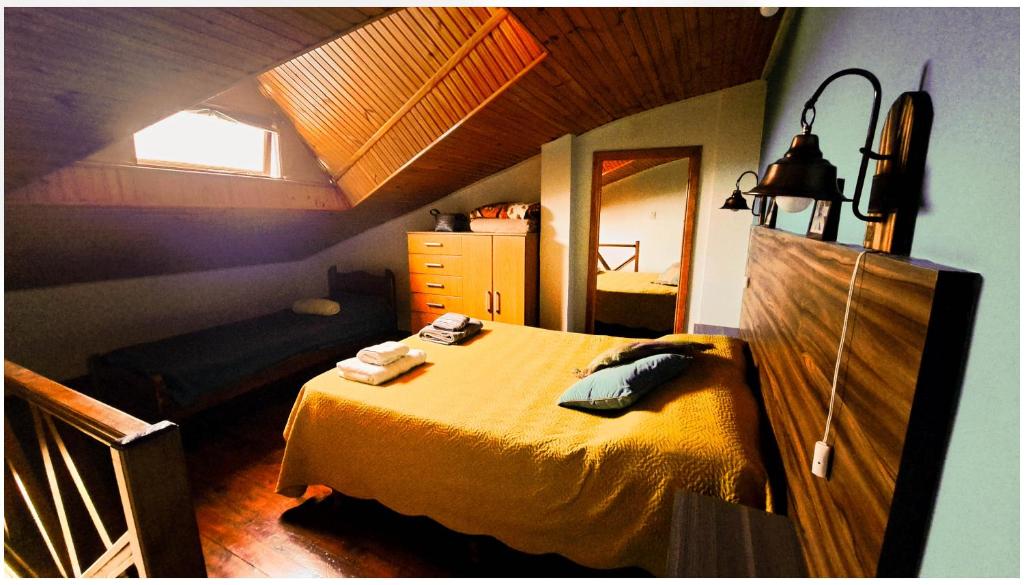 1 dormitorio con cama amarilla en el ático en Terrazas del sur, en Ushuaia
