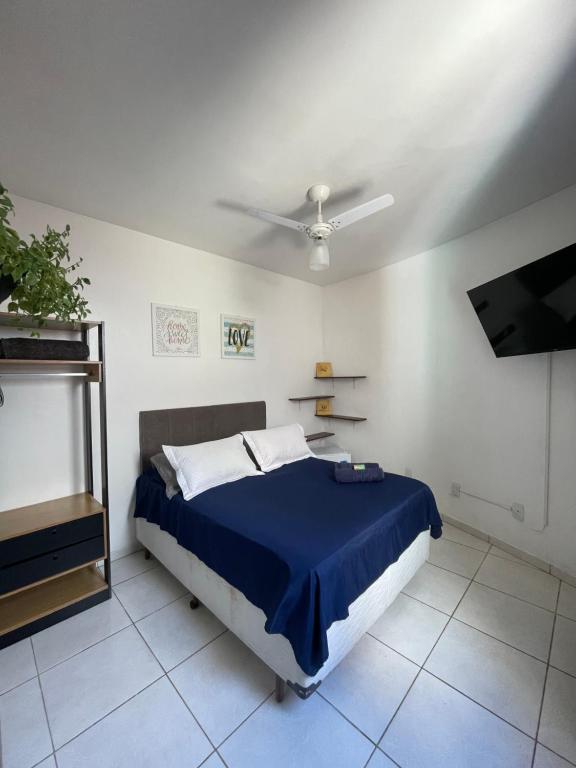 a bedroom with a blue bed and a tv at Casa Estelar in Cabo Frio
