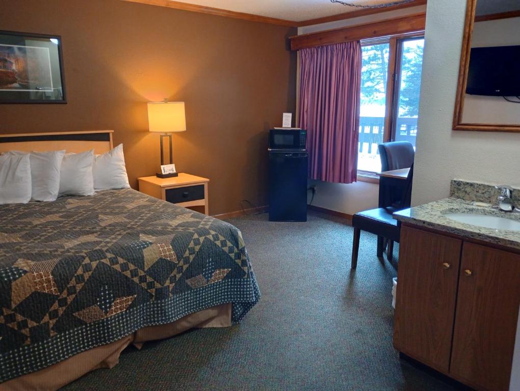 Habitación de hotel con cama y lavabo en Centerstone Resort Lake-Aire en Tomahawk