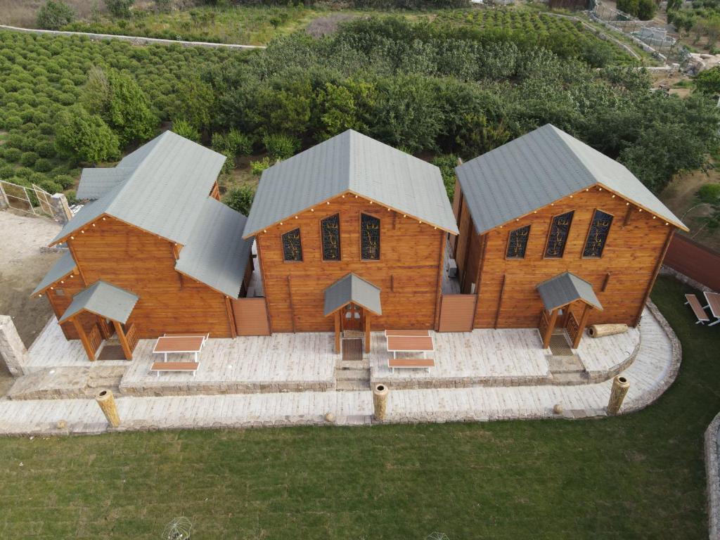 an aerial view of a wooden building with two roofs at KRZ Cottages أكواخ الكرز in Al Shafa