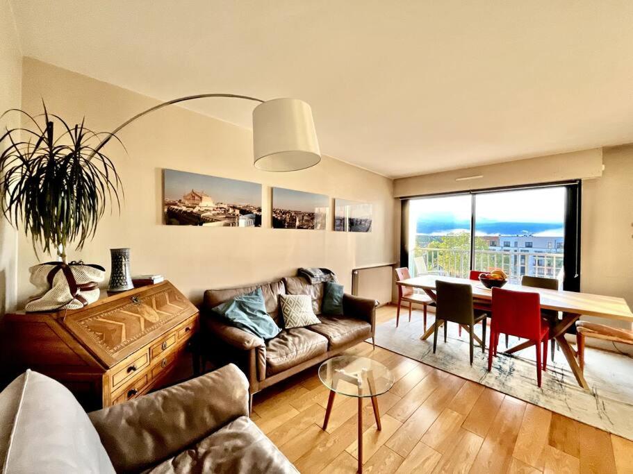 - un salon avec un canapé et une table dans l'établissement Jerickais Appartement à Rueil, à Rueil-Malmaison