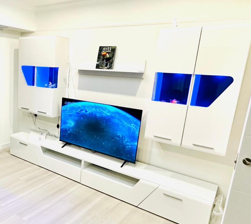 - un salon avec une télévision sur un meuble blanc dans l'établissement Piso Lorena 170m playa Wifi aire, à Puerto de Sagunto