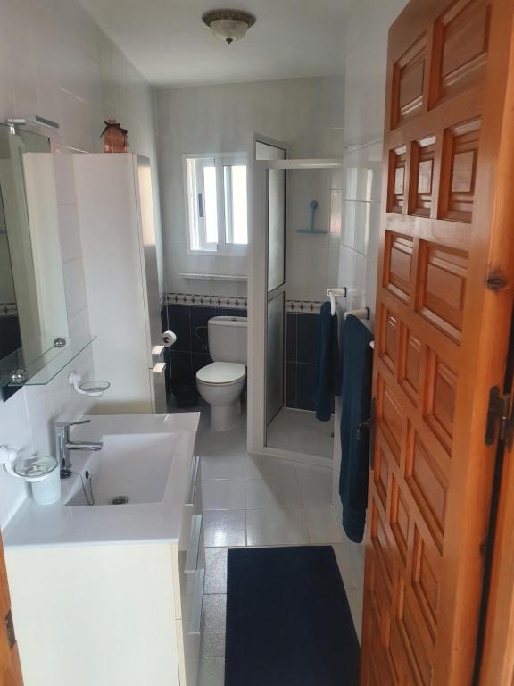 baño con lavabo, aseo y puerta en Casa pajarera, en Fortuna