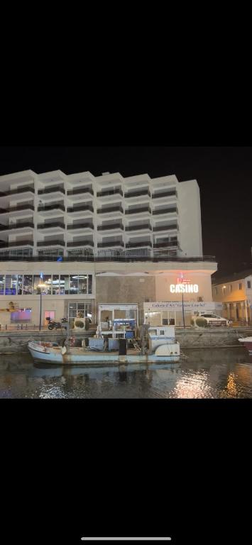 un grand bâtiment avec des bateaux amarrés devant lui dans l'établissement Palais du casino, à Palavas-les-Flots