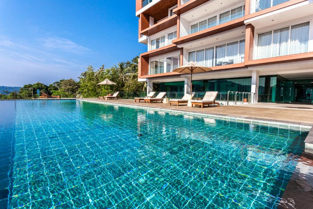 a swimming pool in front of a building at Q Kata Residence in Kata Beach