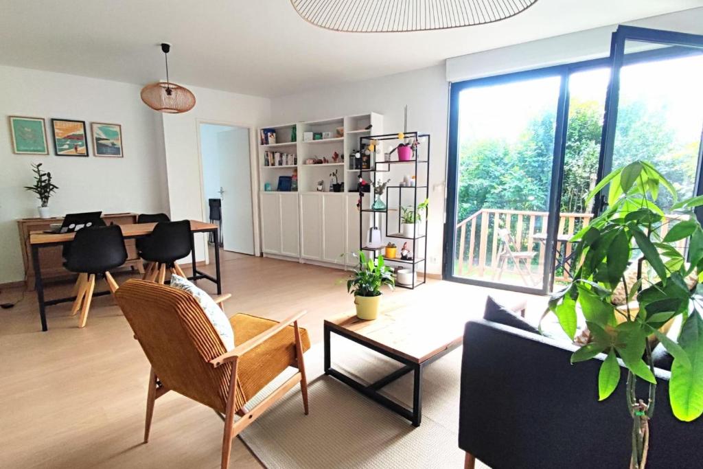 een woonkamer met stoelen en een tafel bij Spacious apartment with garden and parking slot in Bordeaux