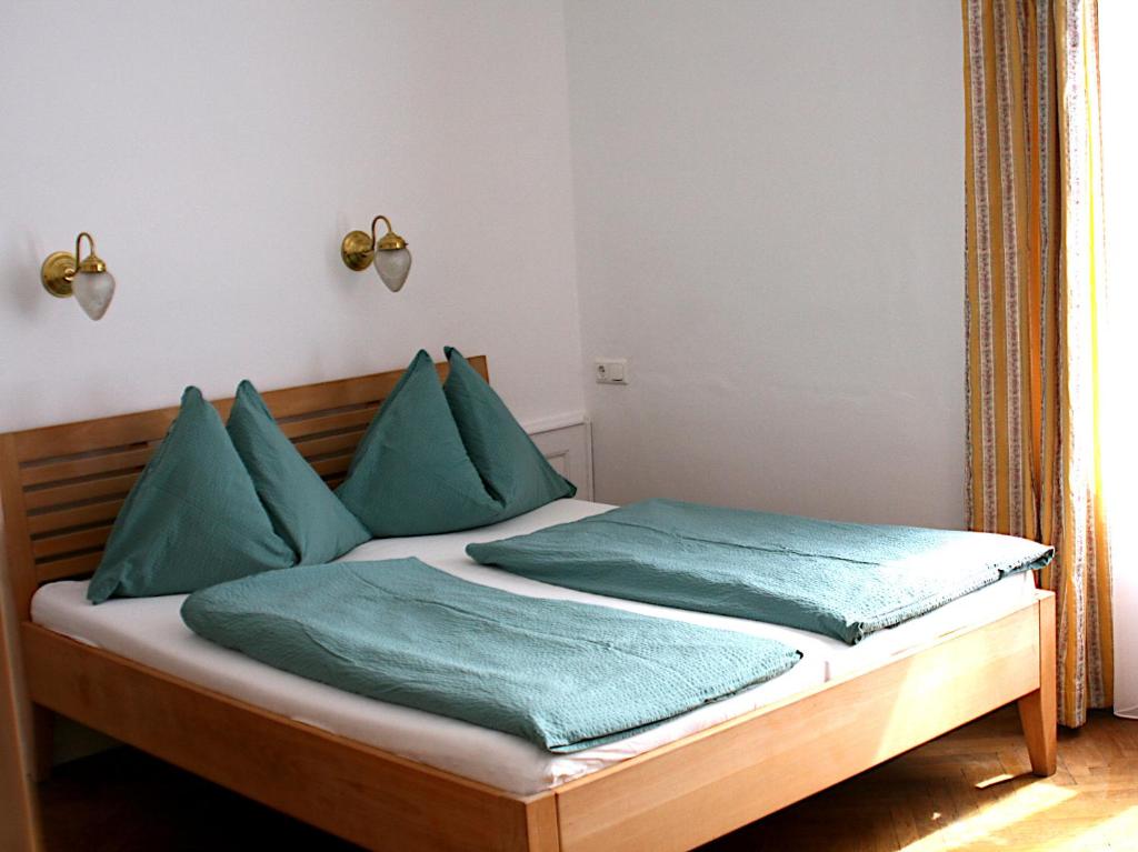 1 dormitorio con 1 cama con almohadas verdes en Seeappartements Excelsior, en Velden am Wörthersee