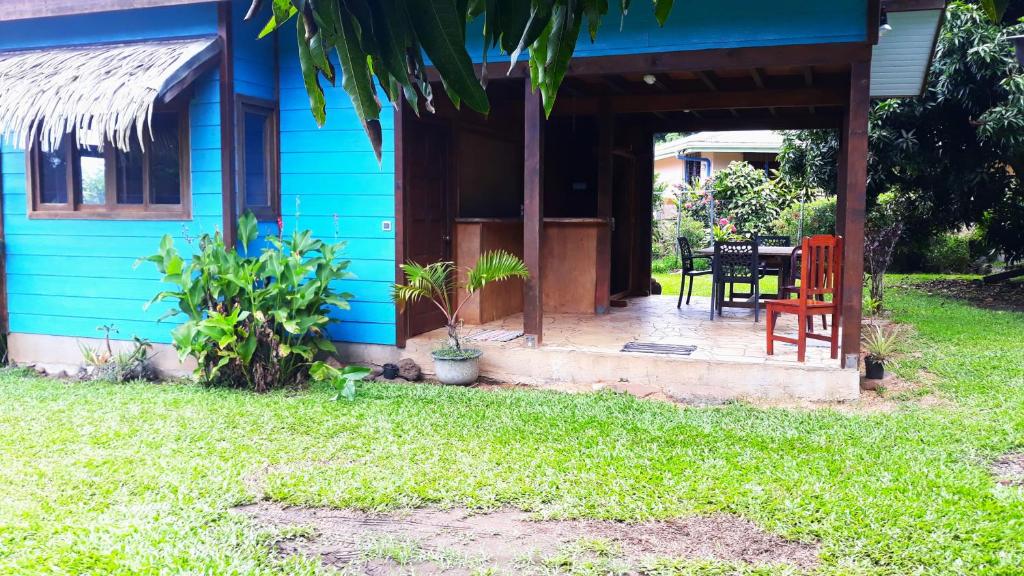 a blue house with a table and chairs in the yard at Faré blue lagoon in Moorea