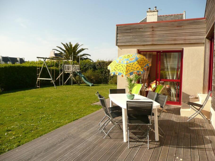 une table et des chaises avec un parasol sur une terrasse dans l'établissement un amour de maison, au Conquet