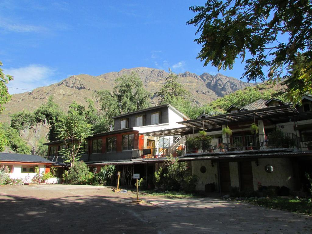 une maison avec une montagne en arrière-plan dans l'établissement Hostal Los Peñones, à San Alfonso