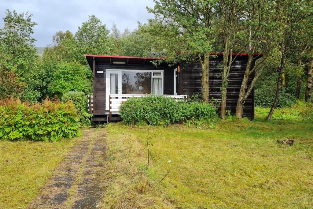 una pequeña cabaña en medio de un campo en Lovely retro cabin close to Geysir and Gullfoss, en Selfoss