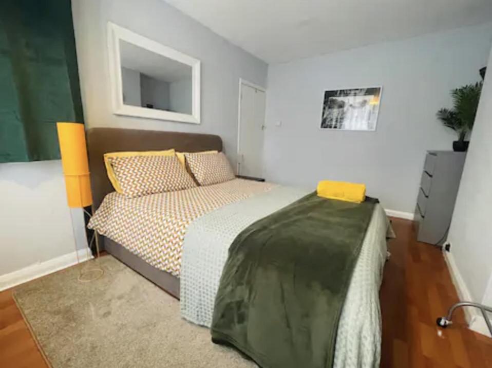 - une chambre avec un lit et un canapé dans l'établissement Serenity Haven, à Hackbridge