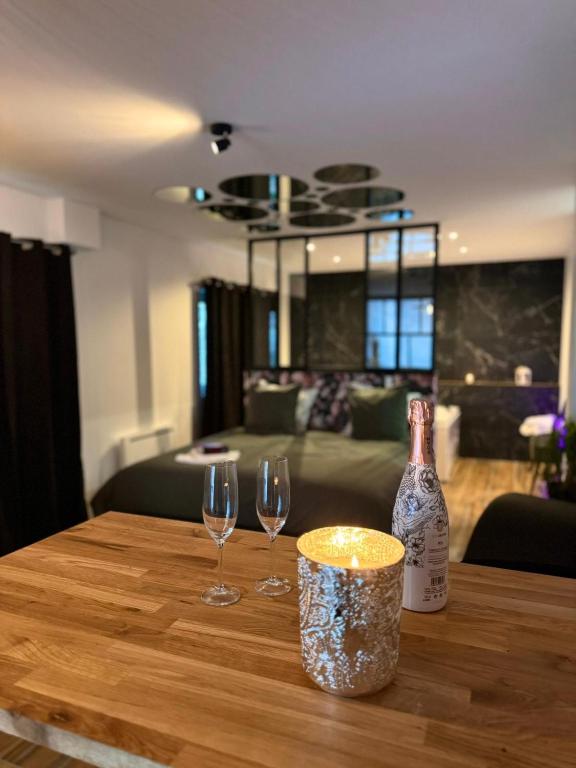 einen Tisch mit zwei Weingläsern und einer Flasche darauf in der Unterkunft The Moon Chambre romantique proche de Nancy in Bouxières-aux-Dames