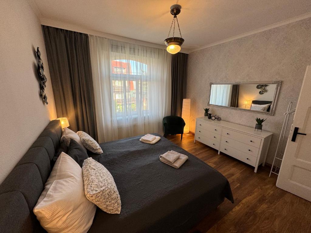 a bedroom with a large bed and a mirror at Apartament ALMAR Cieplice-Zdrój in Jelenia Góra