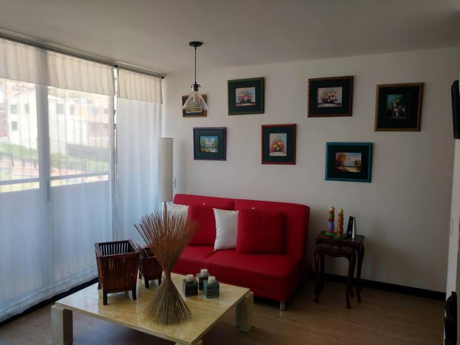 sala de estar con sofá rojo y mesa en Cómodo apartamento en Tocancipa, en Tocancipá