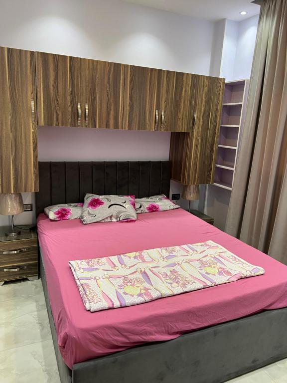 - une chambre avec un lit et une couette rose dans l'établissement pharma beach resort x rent قرية الصيادلة بلطيم, à Al Ḩammād