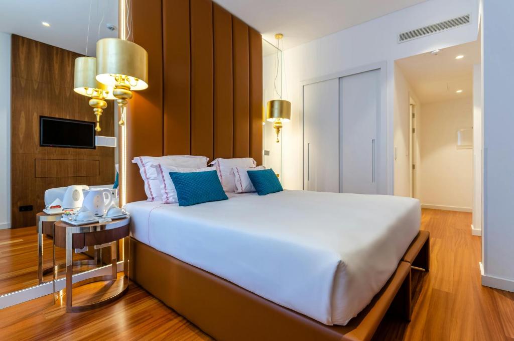 1 dormitorio con 1 cama blanca grande con almohadas azules en Hotel Aurora Mirage Delhi, en Nueva Delhi