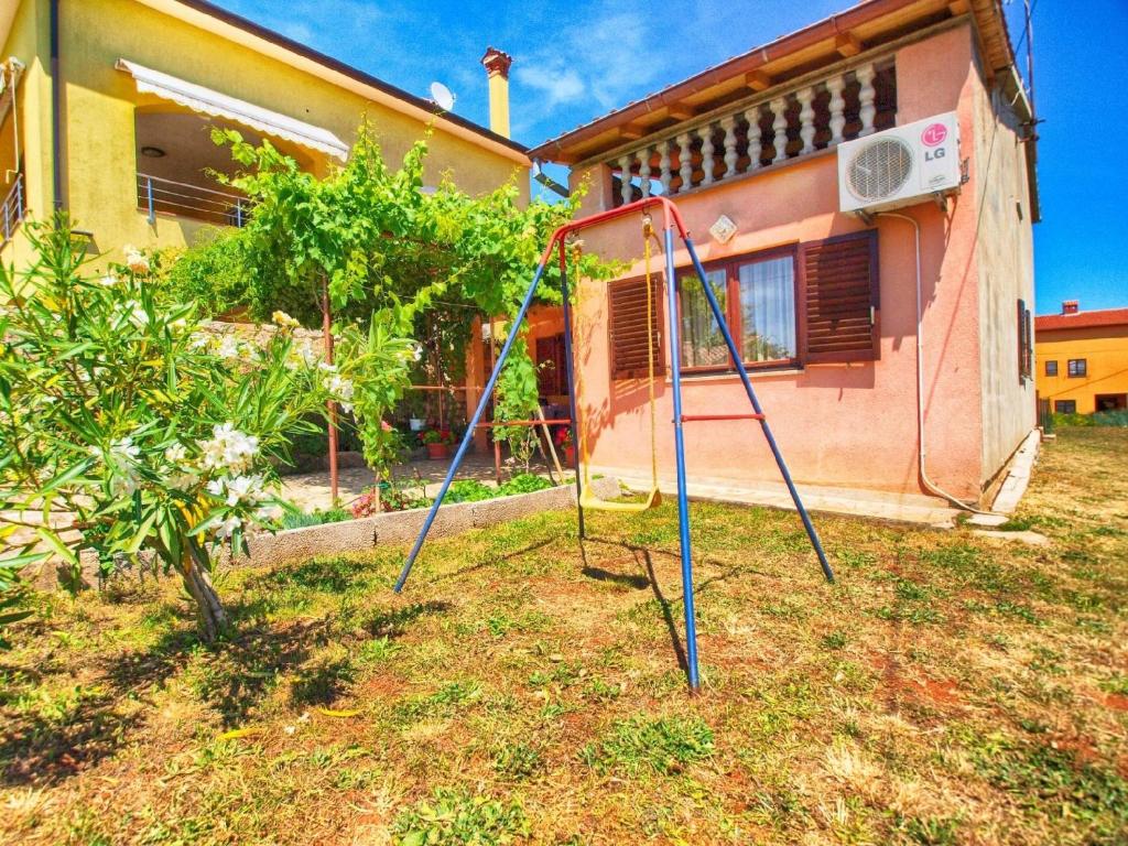 een tuin met twee schommels voor een huis bij Ferienwohnung für 5 Personen ca 75 qm in Marčana, Istrien Südküste von Istrien in Marčana