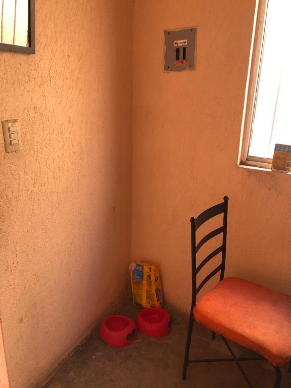 una habitación con una silla y algunos tazones de comida en Casa En Los Manantiales, en Jacona de Plancarte
