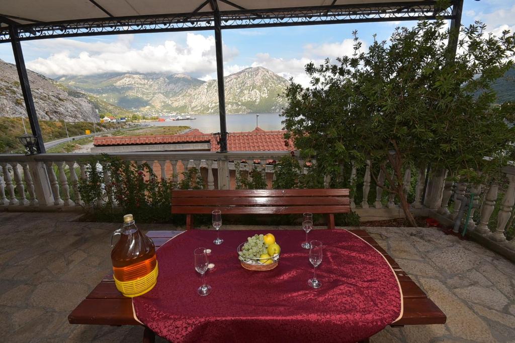 stół z talerzem jedzenia i kieliszkami do wina w obiekcie Apartments Morinj w mieście Donji Morinj