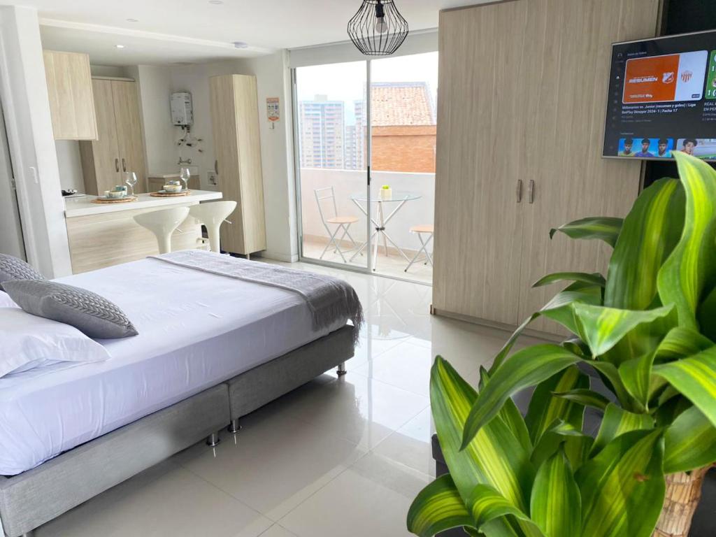 a bedroom with a bed and a kitchen with a balcony at Mio Loft in Medellín