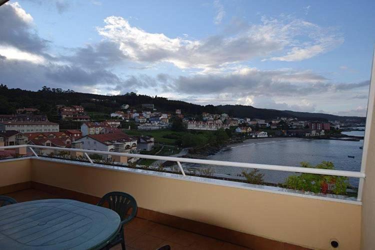 balcón con mesa y vistas al río en Apartamento Playa de Quenxe - Corcubión, en Corcubión