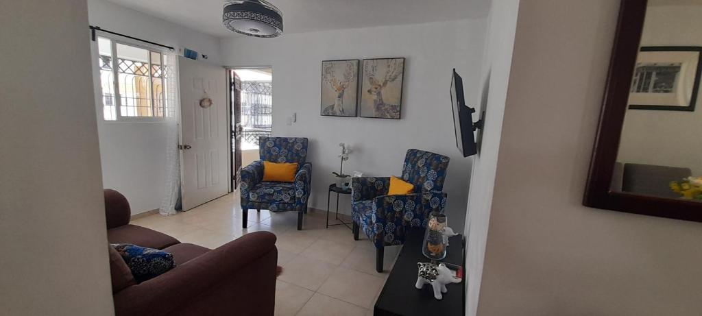 a living room with a couch and chairs and a table at Residencial Palmas De Gurabo in Santiago de los Caballeros