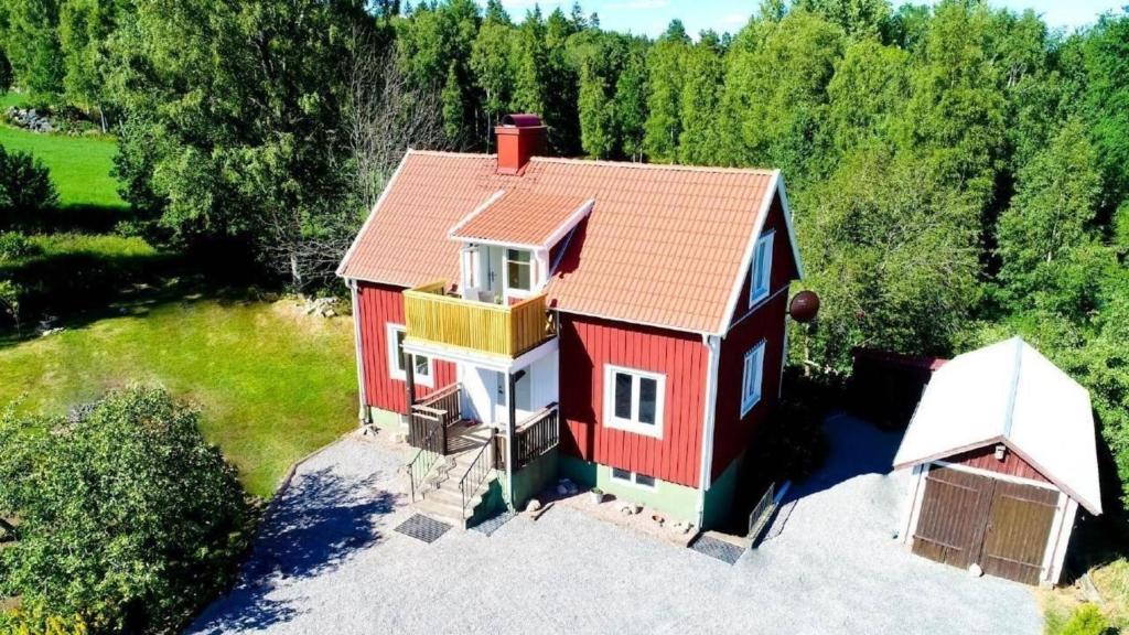 einen Blick über ein rotes Haus mit rotem Dach in der Unterkunft Smålandhaus "Lindhaga" mit Aussicht über Ruskensee 