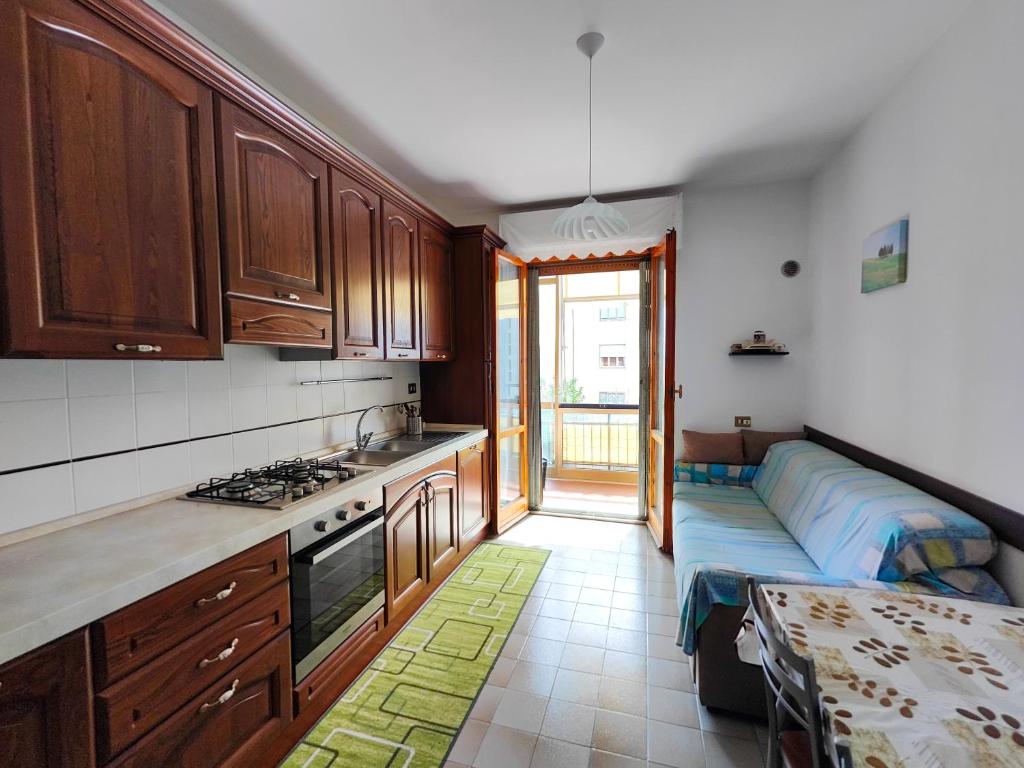 una cucina con armadi in legno e un divano. di Cozy Room in Florence Metro Area a Sesto Fiorentino