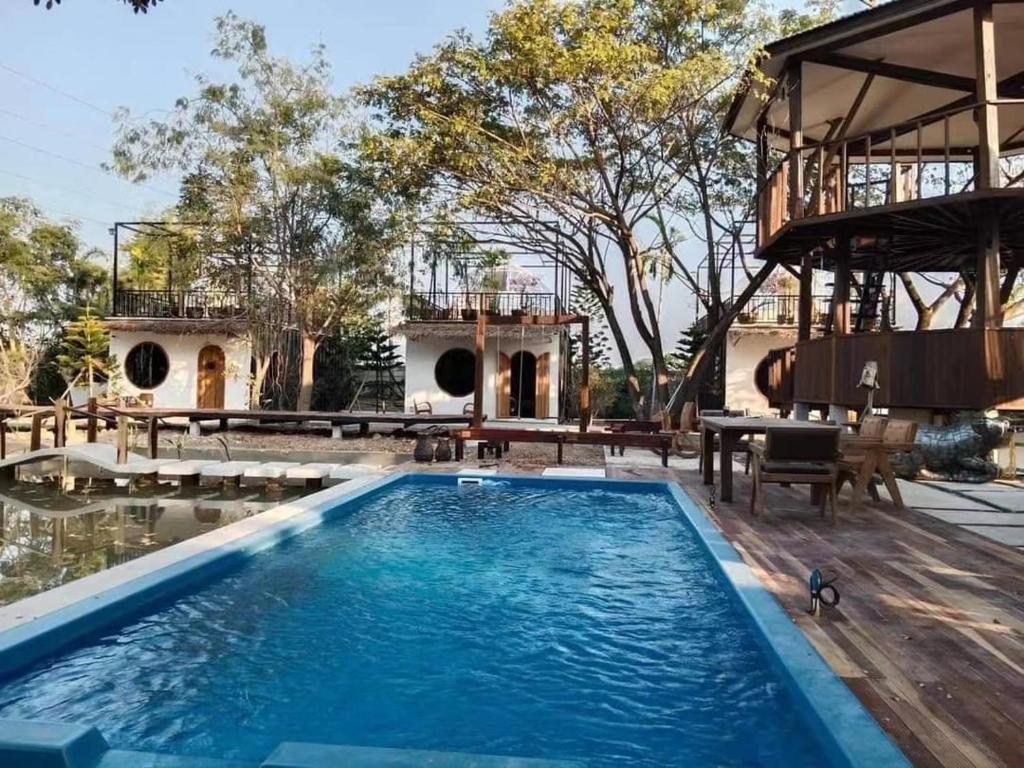 einen Pool mit Terrasse und ein Haus in der Unterkunft free tribe in Chiang Mai