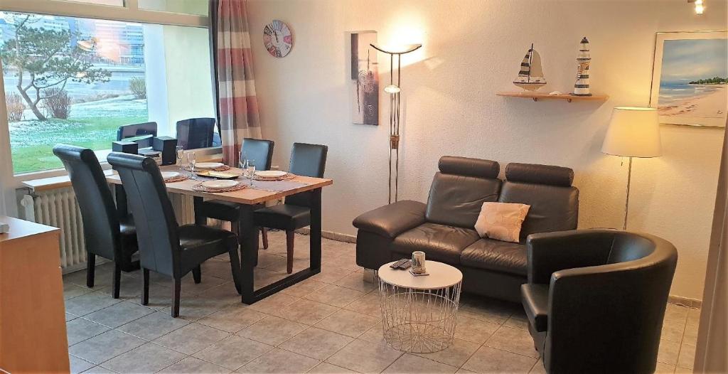 ein Wohnzimmer mit einem Tisch und einem Sofa in der Unterkunft Strandurlaub im Ferienappartement mit Garten - b57340 in Heiligenhafen