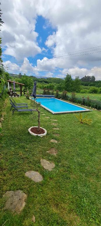 a swimming pool in the middle of a yard at Carlana House in Paredes de Coura