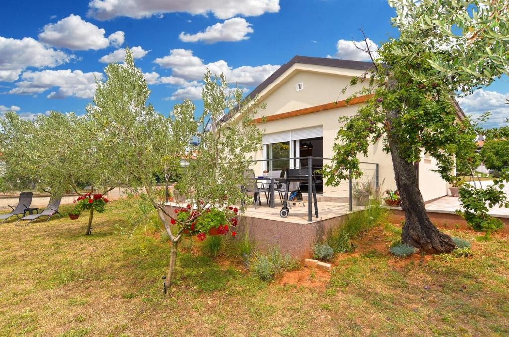 a house with a patio and trees at Ferienhaus für 4 Personen ca 74 qm in Medulin, Istrien Südküste von Istrien in Medulin