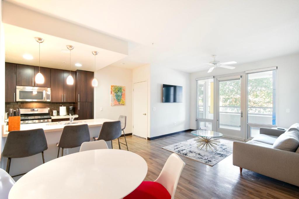 una sala de estar de planta abierta y una cocina con mesa y sillas. en 2BR Modern Luxury Oasis WeHo, en Los Ángeles