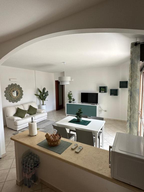 eine große Küche und ein Wohnzimmer mit einem Tisch in der Unterkunft Santu Marcu apartment in Decimomannu