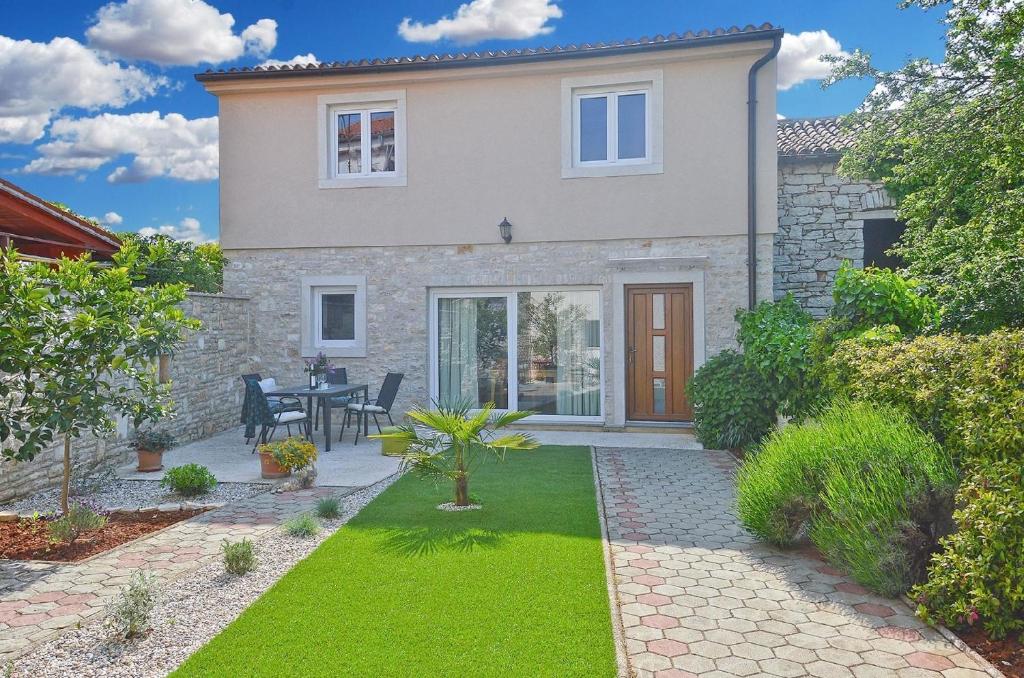 a house with a garden and a patio at Ferienhaus für 6 Personen ca 86 qm in Peroj, Istrien Istrische Riviera in Peroj