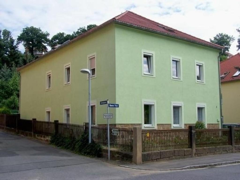 una casa verde sul lato di una strada di Gemütliche Wohnung in Pirna mit Großem Garten a Pirna