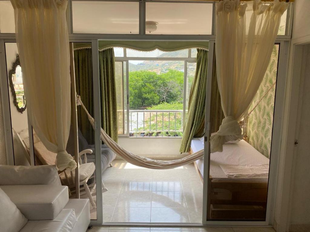 ein Zimmer mit einer Hängematte vor einem Fenster in der Unterkunft Apartamento Amoblado en Rodadero de Santa Marta in Rodadero