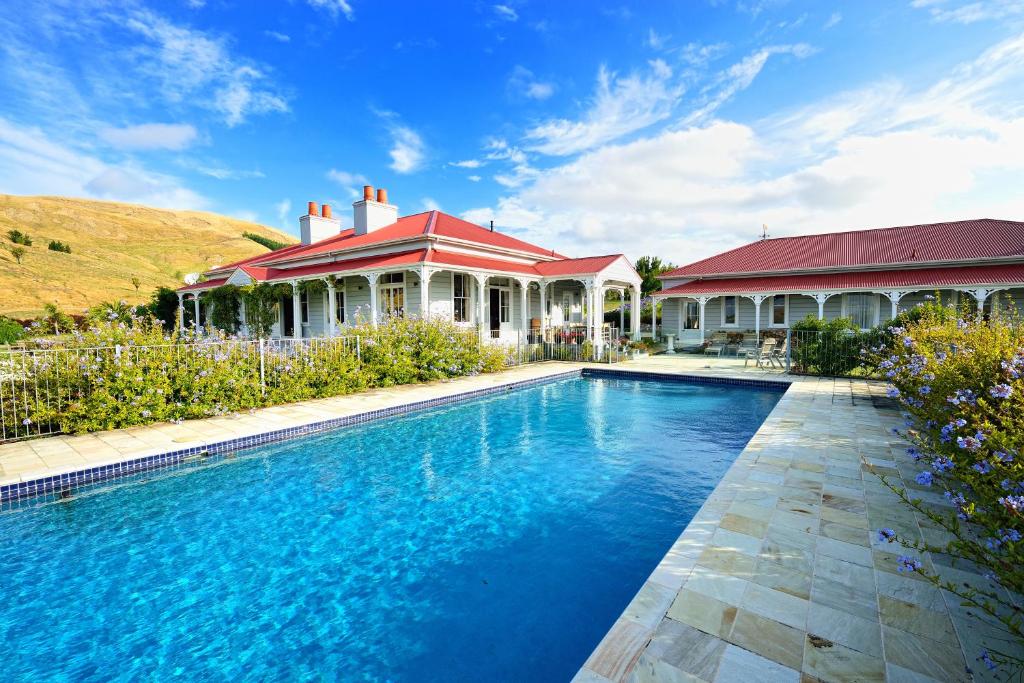 a house with a swimming pool in front of a house at Cape South Estate - International award-winning country estate with Pacific views in Havelock North