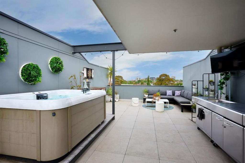 a kitchen with a large tub and a patio at 2BR Penthouse Apt Rooftop Terrace, Spa & BBQ in Melbourne