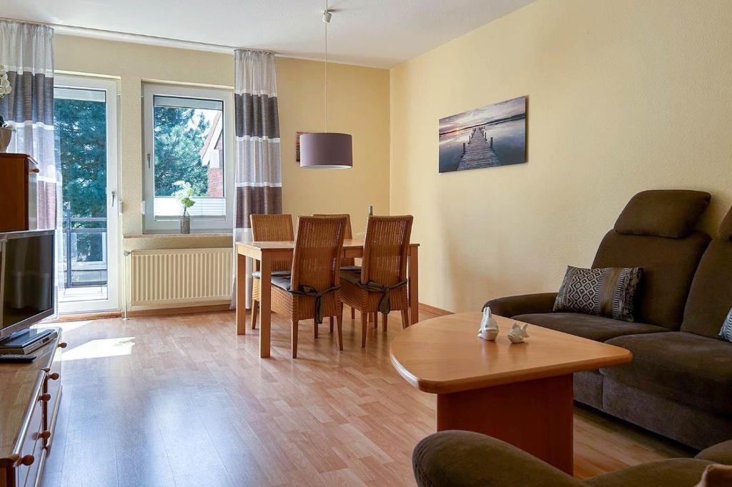 sala de estar con sofá y mesa de comedor en Ferienwohnung-4-mit-Sonnenbalkon-im-Landhaus-Hubertus-Duhnen, en Cuxhaven