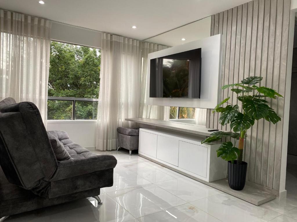 een woonkamer met een stoel en een televisie bij Hermoso apartamento en El Poblado in Medellín