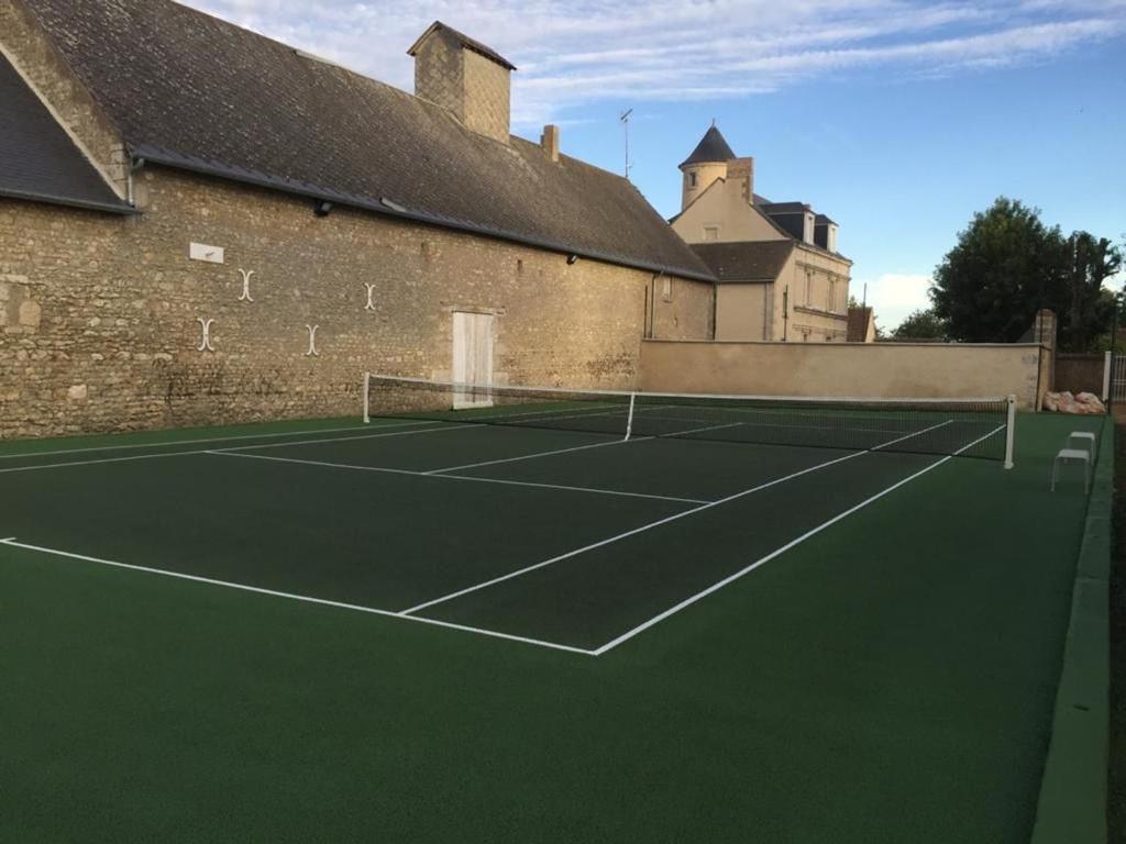 a tennis court in front of a building at Maison lumineuse avec jardin privatif, proche châteaux de la Loire, tennis gratuit et charme historique - FR-1-581-69 in Châteaudun