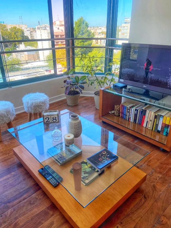 a living room with a glass table and a tv at Edificio Millenium Apartment in Mendoza