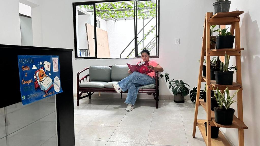 un homme assis sur un canapé dans un salon dans l'établissement Better and Cheaper, à Medellín