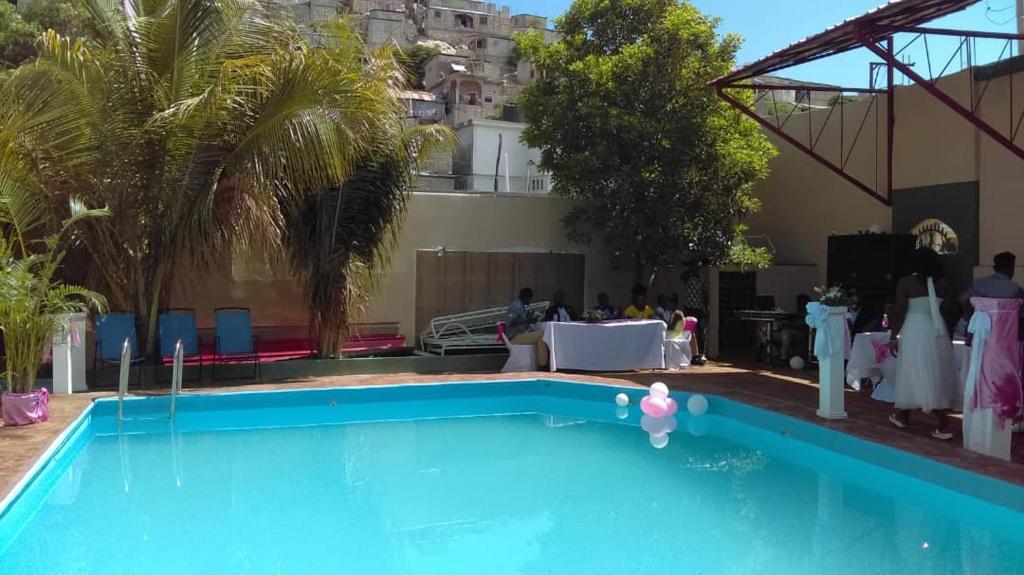 una piscina en un hotel con mesa y sillas en Hotel en Saint-Marc