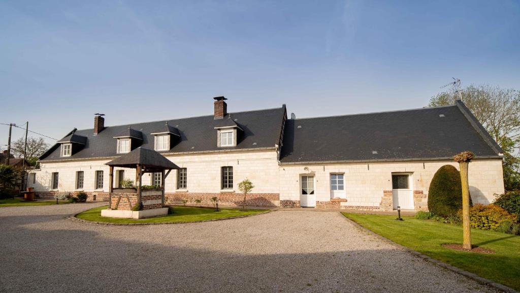 una gran casa blanca con techo negro en Domaine des demoiselles - Chambres d'hôtes en Hauteville