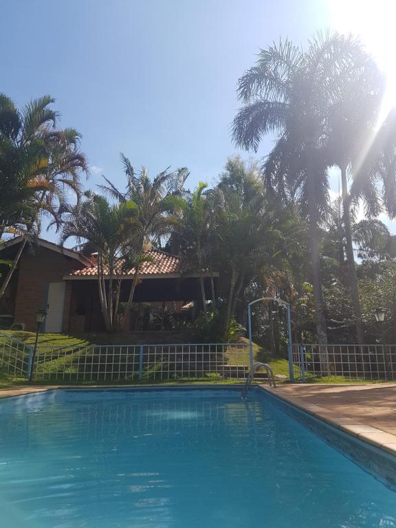 una piscina frente a una casa con palmeras en Casa de Campo em Itatiba en Itatiba