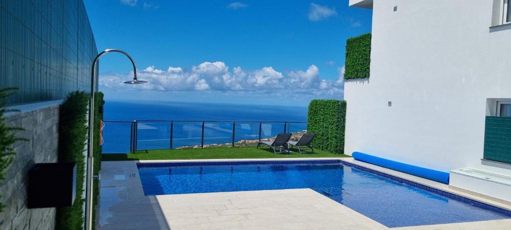 a swimming pool with a view of the ocean at Casa Mar Azul in Arco da Calheta